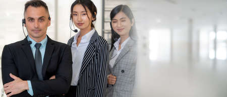 Business people wearing headset working in office to support remote customer or colleague. Call center, telemarketing, customer support agent provide service in broaden view .の写真素材