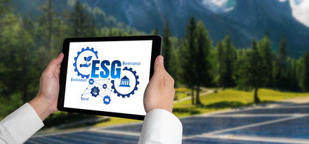 Green business transformation for environment saving and ESG business concept. Businessman using tablet to set corporate goal toward environmental friendly management and alternative clean energy use.の写真素材