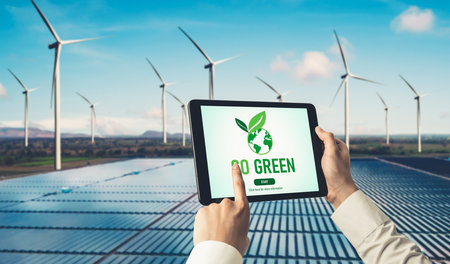 Green business transformation for environment saving and ESG business concept. Businessman using tablet to set corporate goal toward environmental friendly management and alternative clean energy use.の写真素材