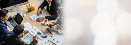 Business people group meeting shot from top widen view in office . Profession businesswomen, businessmen and office workers working in team conference with project planning document on meeting table .の写真素材