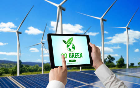 Green business transformation for environment saving and ESG business concept. Businessman using tablet to set corporate goal toward environmental friendly management and alternative clean energy use.の写真素材