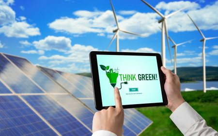 Green business transformation for environment saving and ESG business concept. Businessman using tablet to set corporate goal toward environmental friendly management and alternative clean energy use.の写真素材