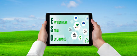 Green business transformation for environment saving and ESG business concept. Businessman using tablet to set corporate goal toward environmental friendly management and alternative clean energy use.の写真素材