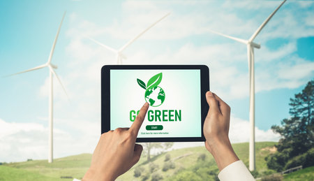 Green business transformation for environment saving and ESG business concept. Businessman using tablet to set corporate goal toward environmental friendly management and alternative clean energy use.の写真素材