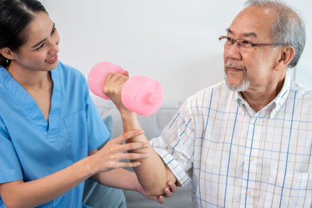 Contented senior patient doing physical therapy with the help of his caregiver. Senior physical...