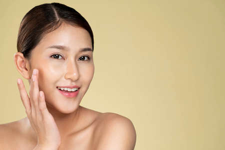 Closeup ardent young woman with healthy clear skin and soft makeup looking at camera and posing beauty gesture. Cosmetology skincare and beauty concept.の写真素材