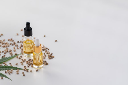 Sets of legalized marijuana features with CBD oil in bottle with dropper lid, sativa green hemp, and hemp seeds. Cannabis product for copyspace and advertisement.の写真素材