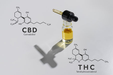 CBD oil in a clear, glass container with a dropper lid, isolated on a white background and biochemistry formula hexagon illustration, to represent the legalized marijuana extracts concept.の写真素材