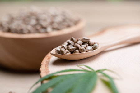 Hemp seeds on round wooden bowl with hemp leaf. Legalized cannabis concept for medical and healthcare purpose.の写真素材