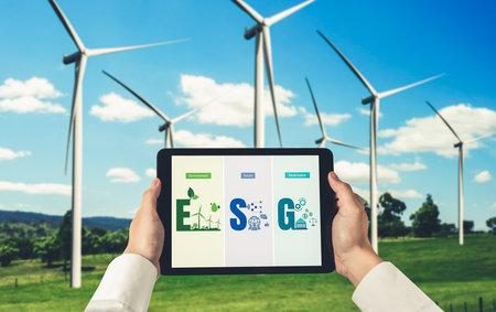Green business transformation for environment saving and ESG business concept. Businessman using tablet to set corporate goal toward environmental friendly management and alternative clean energy use.の写真素材