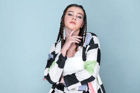 Closeup beautiful young girl with perfect skin, cosmetic and long braid posing with trendy fashion...