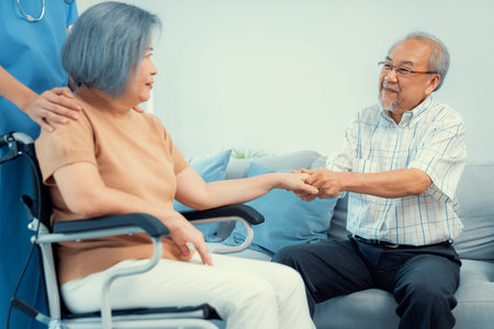 A contented senior couple and their in-home nurse. Elderly female in wheelchair with her young...
