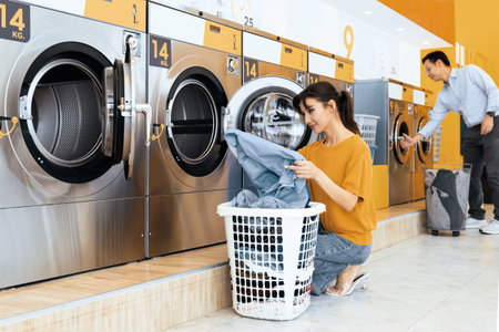 Asian people using qualified coin operated laundry machine in the public room to wash their cloths....