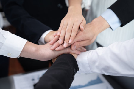Top view closeup business team of suit-clad businesspeople join hand stack together. Colleague...