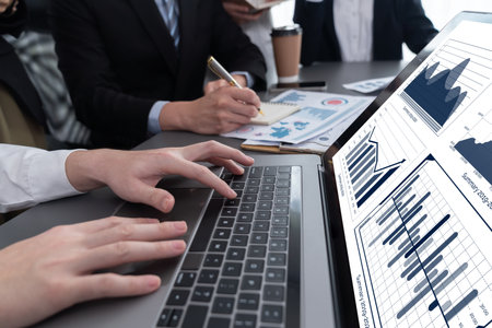 Business team analyze business analytic or business intelligence dashboard on laptop screen show graph and chart with statistic in harmony office. Analyst team meeting researching, planning strategy.の写真素材