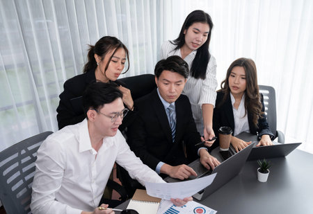 Harmony in office concept as business people analyzing dashboard paper together in workplace. Young...
