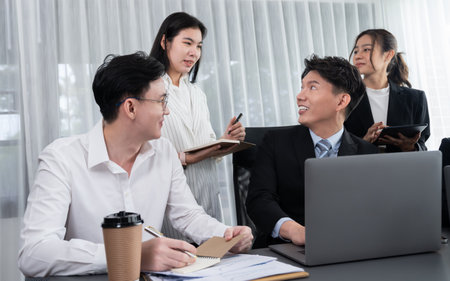 Harmony in office concept as business people analyzing dashboard paper together in workplace. Young colleagues give ideas at manager desk for discussion or strategy planning about project.の写真素材