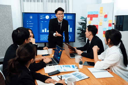 Confidence and asian businessman give presentation on financial analyzed by business intelligence in dashboard report to other people in board room meeting to promote harmony in workplace.の写真素材