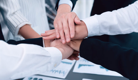 Top view closeup business team of suit-clad businesspeople join hand stack together. Colleague...