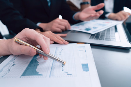 Business team analyze business analytic or business intelligence dashboard on laptop screen show graph and chart with statistic in harmony office. Analyst team meeting researching, planning strategy.の写真素材