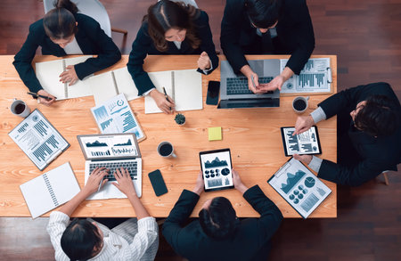 Top-view business team of financial data analysis meeting with business intelligence, report paper and dashboard on laptop for marketing strategy. Business people working together in office of harmonyの写真素材