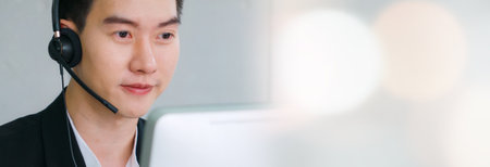 Business people wearing headset working in office in widen view to support remote customer or colleague. Call center, telemarketing, customer support agent provide service on telephone video call.の写真素材