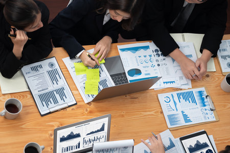Top-view business team of financial data analysis meeting with business intelligence, report paper and dashboard on laptop for marketing strategy. Business people working together in office of harmonyの写真素材