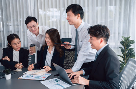Harmony in office concept as business people analyzing dashboard paper together in workplace. Young colleagues give ideas at manager desk for discussion or strategy planning about project.の写真素材
