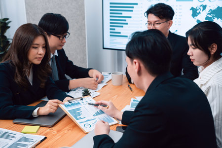 Business team of financial data analysis meeting with business intelligence, report paper and dashboard on laptop for marketing strategy. Business people working together to promote harmony in office.の写真素材