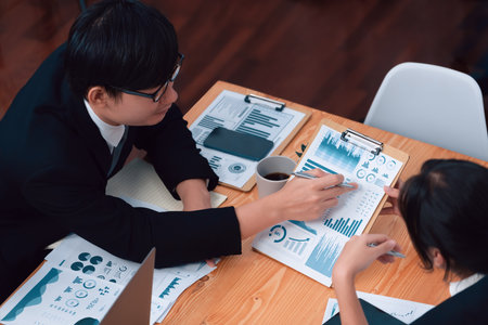 Top-view business team of financial data analysis meeting with business intelligence, report paper and dashboard on laptop for marketing strategy. Business people working together in office of harmonyの写真素材