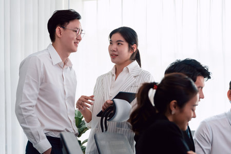 Mentor, manager advice younger colleagues in workplace. Businesspeople discussing or planning financial project strategy, talking together for harmony and strong teamwork in office concept.の写真素材