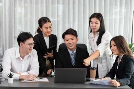 Harmony in office concept as business people analyzing dashboard paper together in workplace. Young colleagues give ideas at manager desk for discussion or strategy planning about project.の写真素材