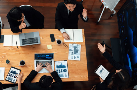 Top-view business team of financial data analysis meeting with business intelligence, report paper and dashboard on laptop for marketing strategy. Business people working together in office of harmonyの写真素材