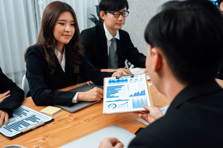 Business team of financial data analysis meeting with business intelligence, report paper and dashboard on laptop for marketing strategy. Business people working together to promote harmony in office.の写真素材