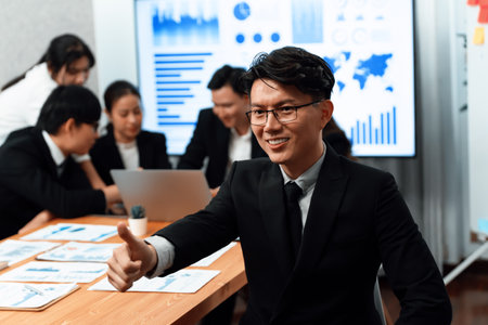 Focus portrait of successful confident male manager or executive in business wear with blurred background of businesspeople, colleagues working with financial report papers in office of harmony.の写真素材