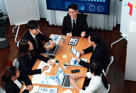 Top-view business team of financial data analysis meeting with business intelligence, report paper and dashboard on laptop for marketing strategy. Business people working together in office of harmonyの写真素材