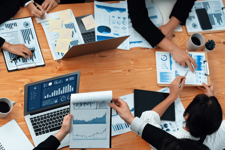 Top-view business team of financial data analysis meeting with business intelligence, report paper and dashboard on laptop for marketing strategy. Business people working together in office of harmonyの写真素材