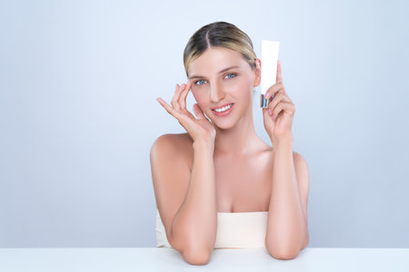 Alluring beautiful perfect cosmetic skin woman portrait hold mockup tube cream or moisturizer for skincare treatment, anti-aging product in isolated background. Natural healthy skin model concept.の写真素材