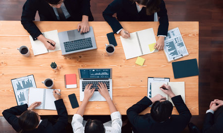 Top view manager or office worker give presentation in harmony conference room to business colleague, BI data dashboard on screen and pile of financial analyzed data reports on meeting table.の写真素材
