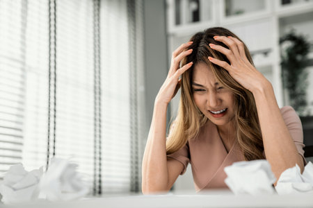 A competent female employee who has become completely exhausted as a result of overburdened work. Concept of unhealthy life as an office worker, office syndrome.の写真素材