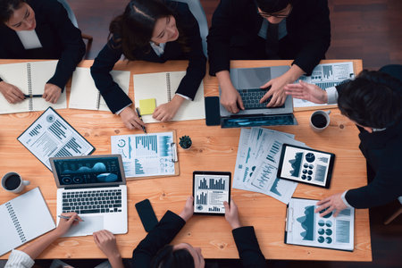 Top-view business team of financial data analysis meeting with business intelligence, report paper and dashboard on laptop for marketing strategy. Business people working together in office of harmonyの写真素材