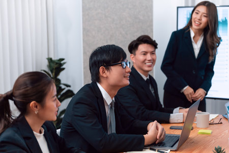 Confidence and young asian businesswoman give presentation on financial business strategy in dashboard report display on screen to colleagues in conference room meeting as harmony in workplace conceptの写真素材