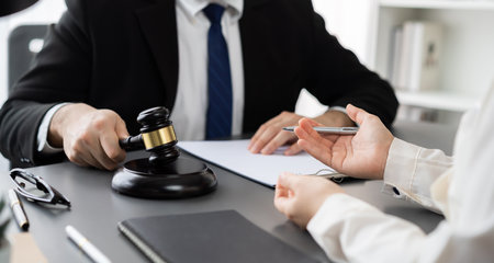 Lawyer colleagues or legal team working or drafting legal document at law firm office desk. Gavel hammer for righteous and equality judgment by lawmaker and attorney. Equilibriumの写真素材