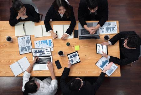 Top-view business team of financial data analysis meeting with business intelligence, report paper and dashboard on laptop for marketing strategy. Business people working together in office of harmonyの写真素材