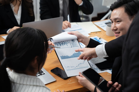 Business team of financial data analysis meeting with business intelligence, report paper and dashboard on laptop for marketing strategy. Business people working together to promote harmony in office.の写真素材