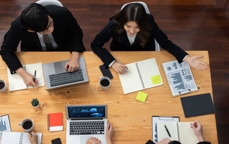 Top-view business team of financial data analysis meeting with business intelligence, report paper and dashboard on laptop for marketing strategy. Business people working together in office of harmonyの写真素材