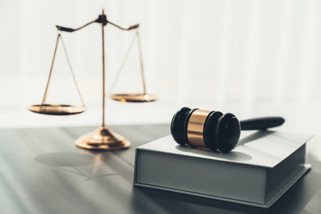 Symbolizing justice and legal authority, golden balanced scale and gavel on desk with law book in lawyer office background, reflecting concept of equality and fair judgment. equilityの写真素材