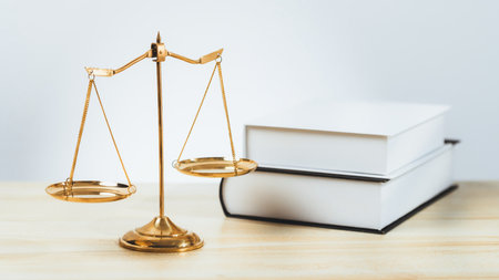 Shiny golden balanced scale and law book on desk in law school as concept justice and legal symbol. Scale balance for righteous and equality judgment by lawyer and attorney. equilityの写真素材