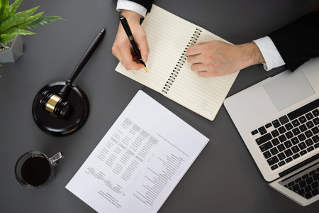 Top view lawyer or judge working on his desk with laptop at law firm or court, drafting legal...