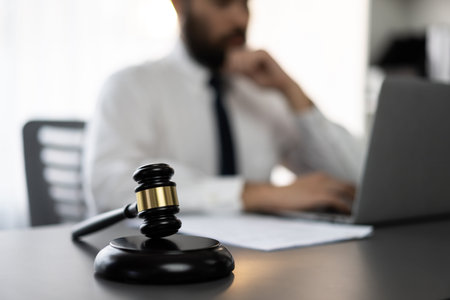 Focus wooden gavel hammer on blur background of lawyer working with legal document on desk at law...